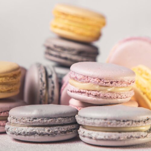 Pink, yellow, and lavender macarons stacked.
